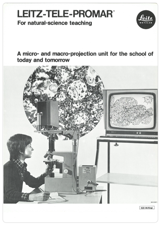 A person looking through a microscope
Description automatically generated